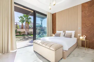 a bedroom with a white bed and a large window at Villa Rafinity Marrakech in Marrakech