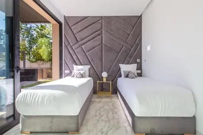 two beds in a room with a large window at Villa Rafinity Marrakech in Marrakech