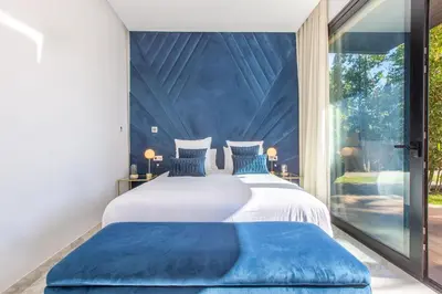 two beds with blue pillows in a room with a window at Palais Rafi in Marrakech
