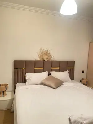 a bedroom with a large bed with white sheets and pillows at Cosy & magnifique appartement Marrakech in Marrakech