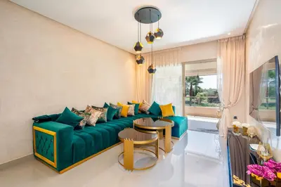 a living room with a green couch and two tables at Exceptional Style Nonstop Luxury in Marrakech