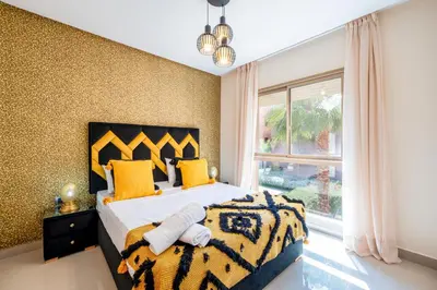 a bedroom with a large bed with yellow pillows and a window at Exceptional Style Nonstop Luxury in Marrakech