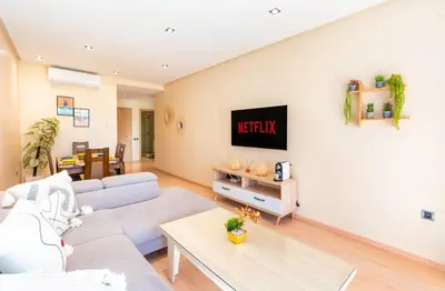 a living room with a couch and a tv on a wall at Relax Front Of Pool-Garden-Fibre in Marrakech