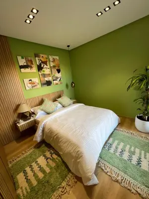 a bedroom with a bed with a green wall at Luxe appartement à louer pour les familles in Marrakech