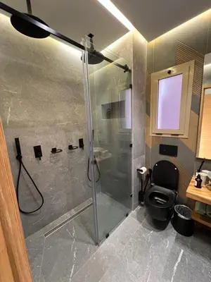 a bathroom with a shower and a black toilet at Luxe appartement à louer pour les familles in Marrakech