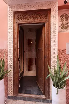 an open door of a building with two potted plants at Riad Garden House Marrakech in Marrakech