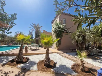 a courtyard with palm trees and a swimming pool at Manzal Lahbab, 2Villas 2Bungalows 2Piscines et Jardins in Marrakech