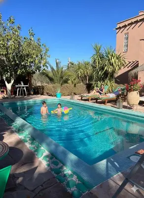 two people in a swimming pool with a frisbee at Manzal Lahbab, 2Villas 2Bungalows 2Piscines et Jardins in Marrakech