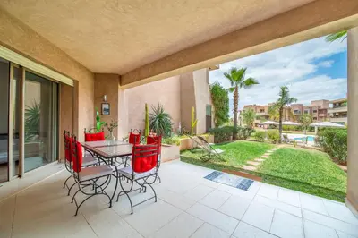 a patio with a table and chairs and a view of a yard at Relaxing Summer-Pool-Garden-Wifi in Marrakech
