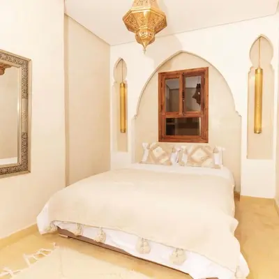 a bedroom with a large white bed with a window at Riad Wadiya, privatif, piscine en rooftop. in Marrakech