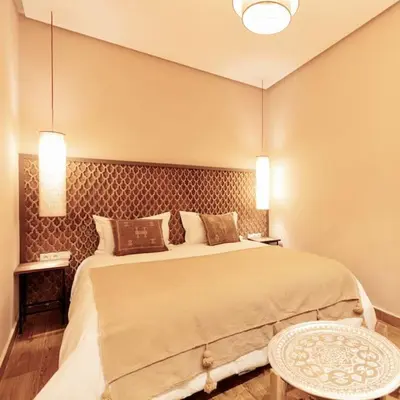 a bedroom with a large bed and two lamps at Riad Wadiya, privatif, piscine en rooftop. in Marrakech