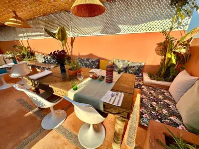 a living room with a wooden table and chairs at Riad 11 Zitoune in Marrakech
