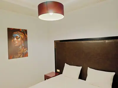a bedroom with a bed and a portrait of a woman at Appartement HIBISCUS 3 chambres avec piscine in Marrakech