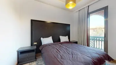 a bedroom with a large bed with a large window at Appartement HIBISCUS 3 chambres avec piscine in Marrakech
