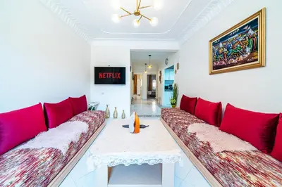 a living room with a red couch and a table at Central appartement in the heart of Guéliz in Marrakech