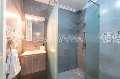 a bathroom with a sink and a shower with a glass door at Central appartement in the heart of Guéliz in Marrakech