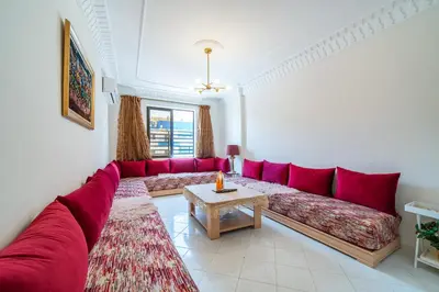 a living room with a red couch and a table at Central appartement in the heart of Guéliz in Marrakech