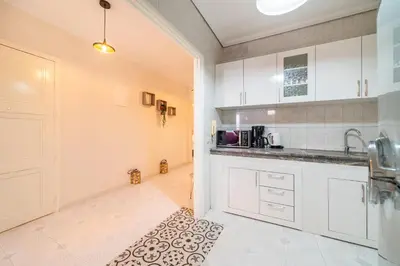 a kitchen with white cabinets and a kitchen rug at Central appartement in the heart of Guéliz in Marrakech