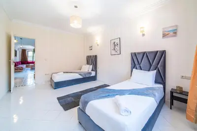 a bedroom with two beds and a living room at Central appartement in the heart of Guéliz in Marrakech