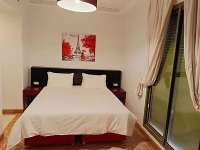 a bedroom with a bed and a window at Appartements de charme à la palmeraie in Marrakech