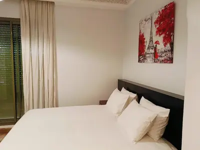 a bedroom with a large bed with white pillows at Appartements de charme à la palmeraie in Marrakech