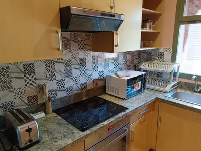 a kitchen with a sink and a stove top oven at Appartements de charme à la palmeraie in Marrakech