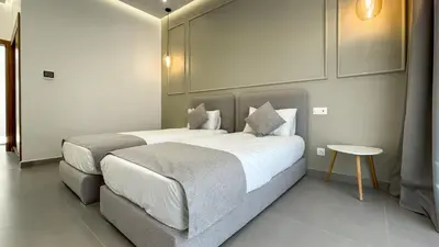 a bedroom with two beds and a table at Villa KOEUR, piscine chauffée sans vis-à-vis à Marrakech in Marrakech