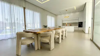 a dining room with a wooden table and chairs at Villa KOEUR, piscine chauffée sans vis-à-vis à Marrakech in Marrakech