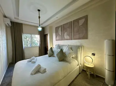 a bedroom with a large white bed with two pillows at Bel Appart Familial Majorelle in Marrakech