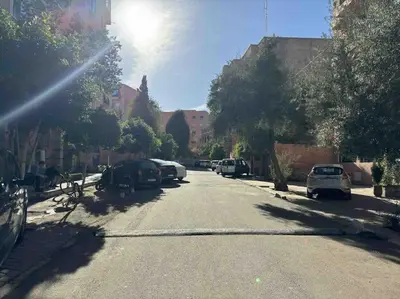 a street with cars parked on the sides of the road at Bel Appart Familial Majorelle in Marrakech