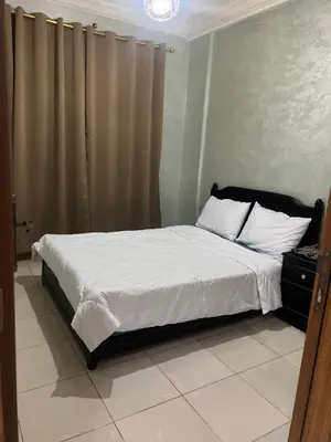 a bedroom with a bed with white sheets and white pillows at Confort Abordable Louez Notre Appartement in Marrakech