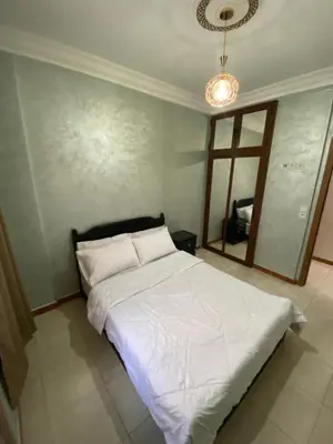 a bedroom with a white bed and a mirror at Confort Abordable Louez Notre Appartement in Marrakech
