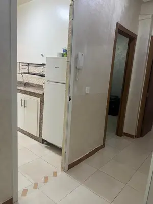 a kitchen with a refrigerator and a door in a room at Confort Abordable Louez Notre Appartement in Marrakech