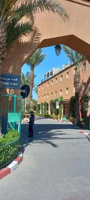 a person standing in the middle of a street with palm trees at Riad Nour Resorts in Marrakech