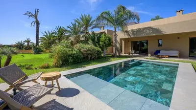 a swimming pool with chairs and a house at Villa Maria, Luxury Marrakech in Marrakech