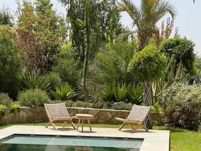 two chairs and a table next to a swimming pool at Villa Maria, Luxury Marrakech in Marrakech