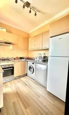 a kitchen with a white refrigerator and a dishwasher at Appartement Denda in Marrakech