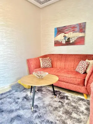 a living room with a red couch and a table at Appartement Denda in Marrakech