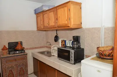 a small kitchen with a microwave and a sink at Cheap accommodation in Marrakech in Marrakech