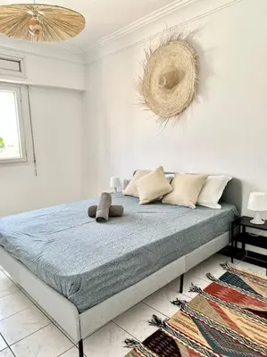 a bedroom with a bed in a white room at Maison de ville avec piscine in Marrakech