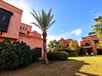 a palm tree in front of a building at Cozy apartment with roof top in Marrakech