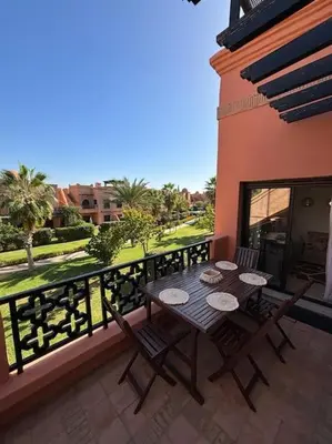 a patio with a table and chairs on a balcony at Cozy apartment with roof top in Marrakech