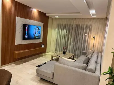 a living room with two couches and a flat screen tv at New appart, pool and golf view in Marrakech