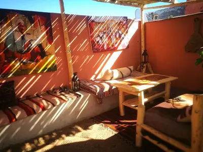 a room with a table and a bench in a room at Dar Mirai in Marrakech