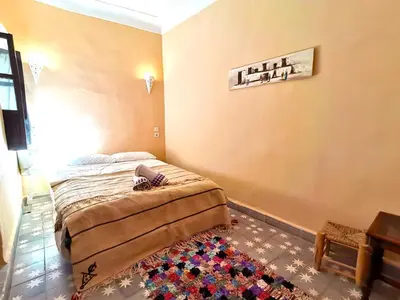 a bedroom with a bed in a room with a rug at Dar Mirai in Marrakech