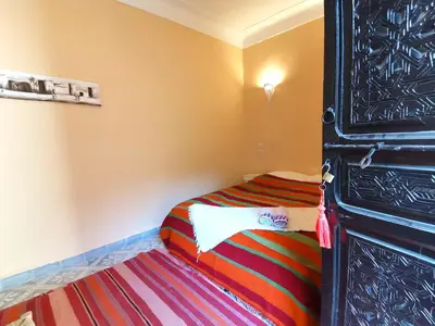 a small bedroom with a bed and a closet at Dar Mirai in Marrakech