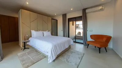 a bedroom with a large white bed and a chair at Loft Atlas in Marrakech