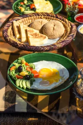 a plate of food with eggs and bread on a table at Riad Bindoo & Spa in Marrakech