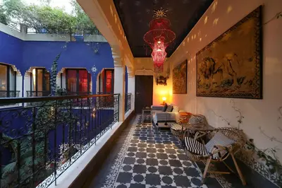 a room with a balcony with chairs and a chandelier at Riad Bindoo & Spa in Marrakech