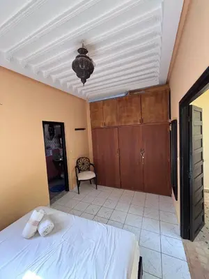 a bedroom with a bed and a chandelier at Riad Paolo Piscine Palmeraie in Marrakech